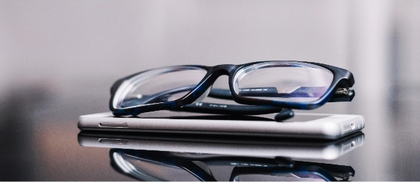 blue-frame-eyeglasses-resting-on-smartphone