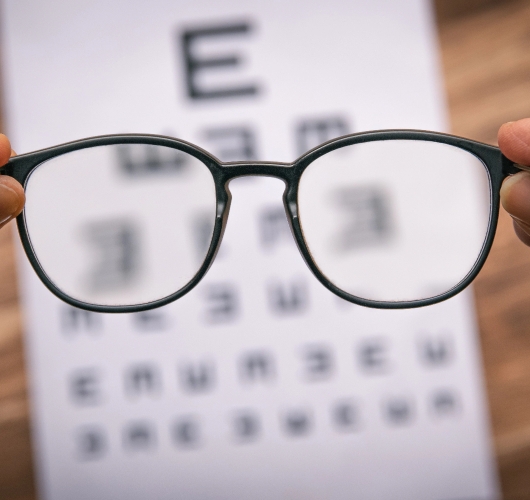 glasses-in-front-of-eye-chart-blurry-vision
