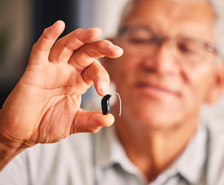 man-holding-hearing-aid-soft-focus