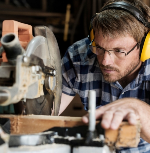 man-using-saw-wearing-safety-glasses-and-ear-protection