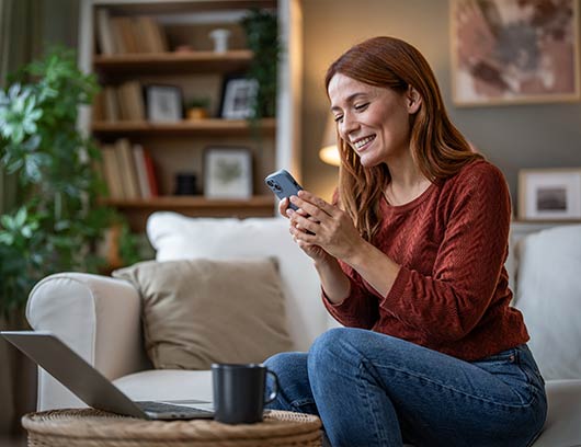 happy-middle-aged-woman-on-phone-with-laptop